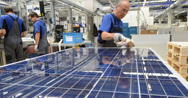 operai che producono pannelli fotovoltaici